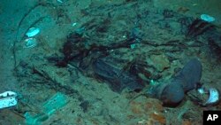 Fotografija iz 2004. koju je dao Institut za istraživanje, Centar za arheološku oceanografiju/Univerzitet Rhode Island/NOAA Ured za istraživanje okeana, prikazuje ostatke kaputa i čizama u blatu na morskom dnu blizu krme Titanika.