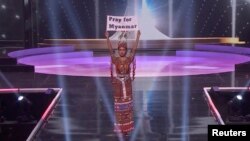 Thuzar Wint Lwin, Miss Universe Myanmar, holds up the "Pray for Myanmar" sign during Miss Universe pageant's national costume show, in Hollywood, Florida, U.S., May 13, 2021. (Courtesy MISS UNIVERSE/Handout via REUTERS)