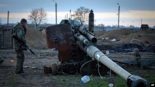 Un soldado ucraniano inspecciona un cañón ruso dañado en la aldea recientemente recuperada de Chornobaivka cerca de Jersón, Ucrania, el martes 15 de noviembre de 2022. (Foto AP/Efrem Lukatsky)