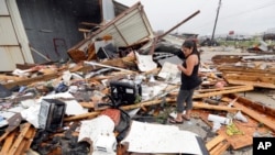 Jennifer Bryant melihat puing-puing kantor milik keluarganya yang rusak dihantam badai Harvey, 26 Agustus 2017 di Katy, Texas. (AP Photo/David J. Phillip)