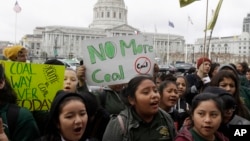 Students yell and hold up signs at a rally for clean energy in San Francisco, Feb. 28, 2018. 