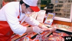 A staff member at a Taipei hyper market examines imported U.S. beef. (File Photo)