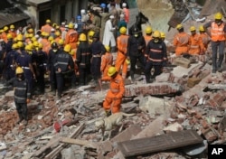 Rescuers work at the site of a building collapse in Mumbai, India, Aug. 31, 2017.