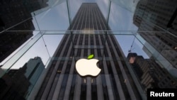 FILE - The leaf on the Apple symbol is tinted green at the Apple flagship store on 5th Ave in New York, April 22, 2014.