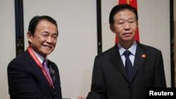 Bộ trưởng Tài chính Trung Quốc Tiêu Tiệp (phải) và Bộ trưởng Tài chính Nhật Bản Taro Aso bắt tay trong cuộc họp song phương bên lề cuộc họp thường niên của Ngân hàng Phát triển Châu Á (ADB), ở Yokohama, Nhật Bản, ngày 6 tháng 5, 2017. 