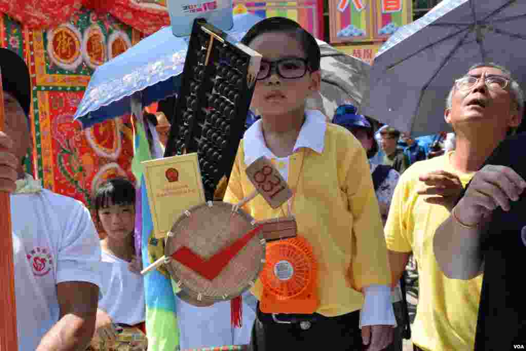 小男孩扮演泛民立法會議員何俊仁，他面前的道具筲箕及小錘子，寓意去年中國全國人大常委會8-31框架有「篩選」及「一錘定音」。（美國之音湯惠芸攝）