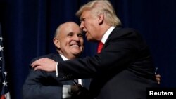 FILE - Republican presidential nominee Donald Trump embraces former New York City Mayor Rudolf Giuliani at a campaign rally in Greenville, N.C., Sept. 6, 2016.