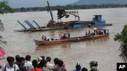 Onlookers watch the search operation for the lost Lao Airlines plane on the banks of the Mekong River in Pakse, Laos, Oct. 17, 2013.