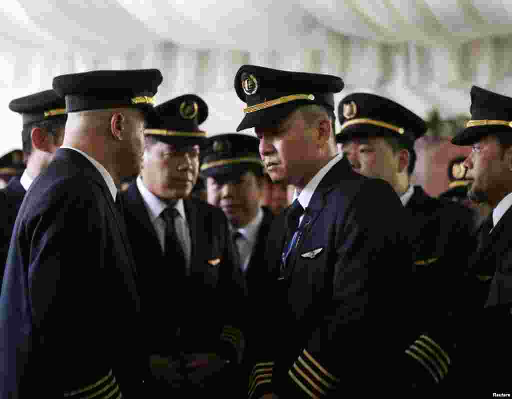 Pilots attend the wake of MH17 co-pilot Eugene Choo, after the return of his remains in Seremban, Sept. 2, 2014.