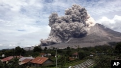 Gunung Sinabung memuntahkan abu vulkanik terlihat dari desa Tiga Serangkai, Sumatra Utara, 1 April lalu (foto: dok).