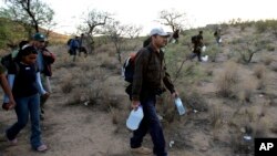 Sekelompok migran berjalan di gurun antara Sasabe, Meksiko, dan Sasabe, Arizona, 25 April 2006. (Foto: Gregory Bull/AP, arsip)