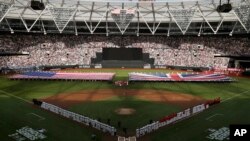Boston Red Sox and New York Yankees players line up as flags are unfurled at London Stadium, June 29, 2019, in London.