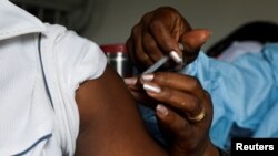 FILE - A man receives a vaccine against the COVID-19 at a mobile vaccination center in Abidjan, Ivory Coast, Sept. 23, 2021. 