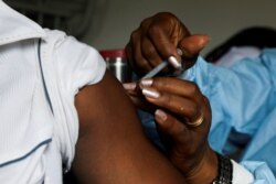 FILE - A man receives a vaccine against the COVID-19 at a mobile vaccination center in Abidjan, Ivory Coast, Sept. 23, 2021.