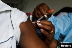 FILE - A man receives a vaccine against the COVID-19 at a mobile vaccination center in Abidjan, Ivory Coast, Sept. 23, 2021.