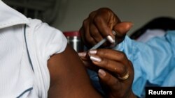 FILE - A man receives a vaccine against the COVID-19 at a mobile vaccination center in Abidjan, Ivory Coast, Sept. 23, 2021. 