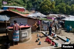 FILE - Rohingya Muslim men collect water from a well at Unchiprang refugee camp near Cox's Bazar, in Bangladesh, Nov. 16, 2018.