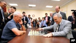 World Chess Champion Garry Kasparov, right, and Rex Sinquefield, founder and president of the Board of Directors of the St. Louis Chess Club, kick-off the first-ever Congressional Chess Match at the Rayburn House Office Building in Washington, D.C., June 18, 2014.