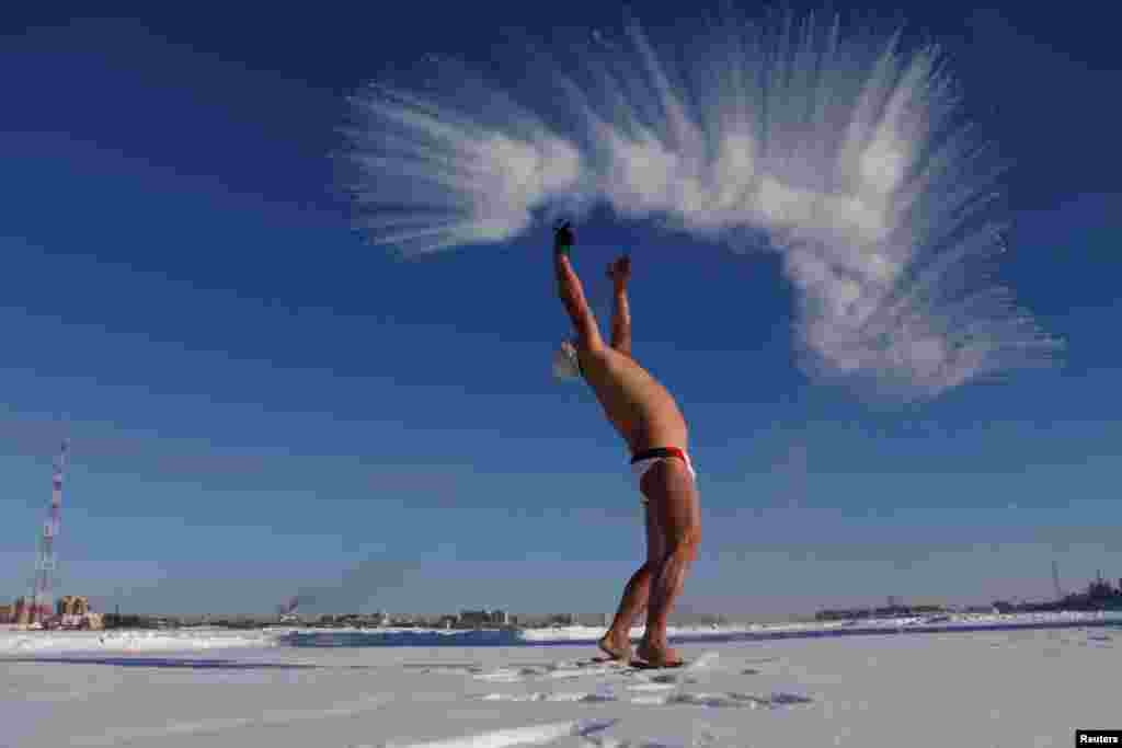 A winter swim lover throws hot water into cold air in Heihe, Heilongjiang province, China, Dec. 27, 2016.