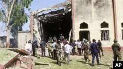 Soldiers stand guard outside St. Rita's Catholic church following a suicide bombing, Kaduna, Nigeria, Oct. 28, 2012.