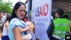 Una mujer venezolana tiene en brazos a una niña en un puesto de salud para migrantes en Cúcuta, en la frontera de Colombia con Venezuela. 