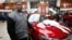 Detroit resident James Robertson reacts next to the 2015 red Ford Taurus sedan he was surprised with as a free gift at the Suburban Ford dealership in Sterling Heights, Michigan, Feb. 5, 2015. 