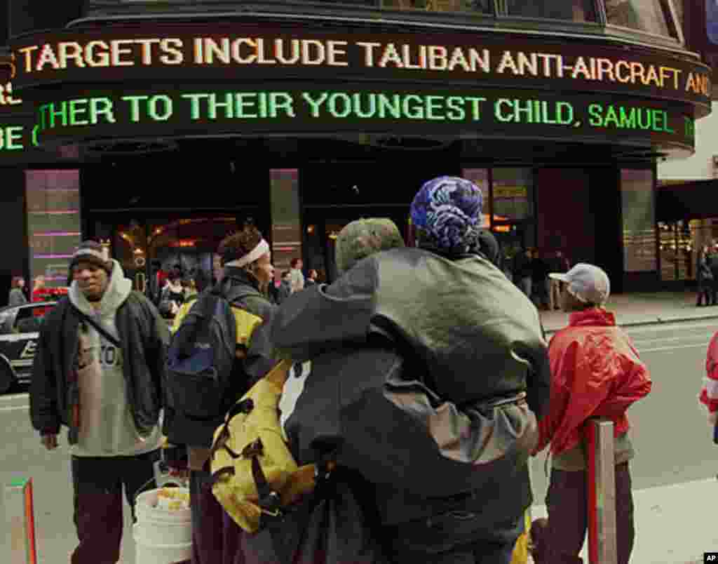 People watch the news on an electronic billboard at Times Square in New York on October 7, 2001, the day that American and British forces unleashed missile attacks against military targets and Osama bin Laden's training camps inside Afghanistan. (AP)