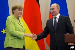 Russian President, Vladimir Putin and German Chancellor Angela Merkel shake hands after their talks in Putin's residence in the Russian Black Sea resort of Sochi, Russia, May 2, 2017.