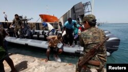 Des migrants clandestins arrivent sous escorte des forces de sécurité à une base de la garde-côte à tripoli, Libye, 6 mai 2017.