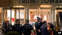 New York firefighters, police officers and others stand outside Trump Tower lobby in New York, Dec 27, 2016.