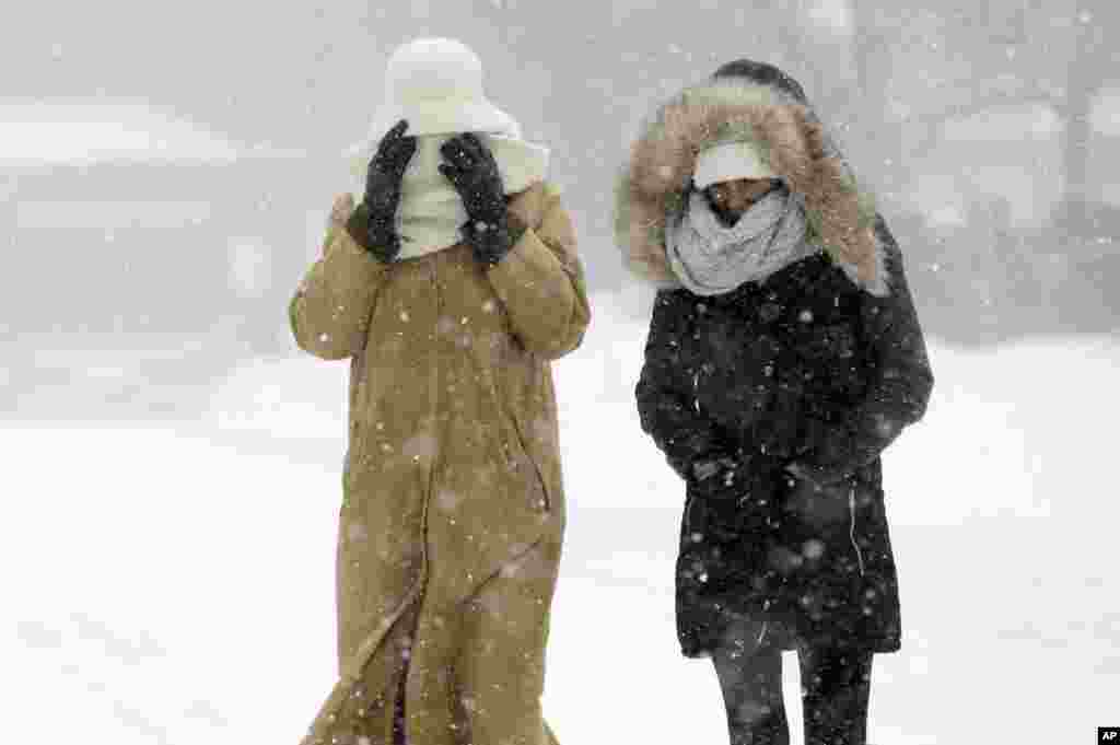 Pedestrians walk bundled against the blowing snow during a winter snowstorm in Boston, Massachusetts, Jan. 27, 2015.