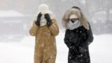 Pedestrians walk bundled against the blowing snow during a winter snowstorm in Boston, Massachusetts, Jan. 27, 2015.