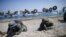 South Korean (blue headbands) and U.S. Marines take positions as amphibious assault vehicles of the South Korean Marine Corps fire smoke bombs during a U.S.-South Korea joint landing operation drill in Pohang, South Korea, March 12, 2016. 