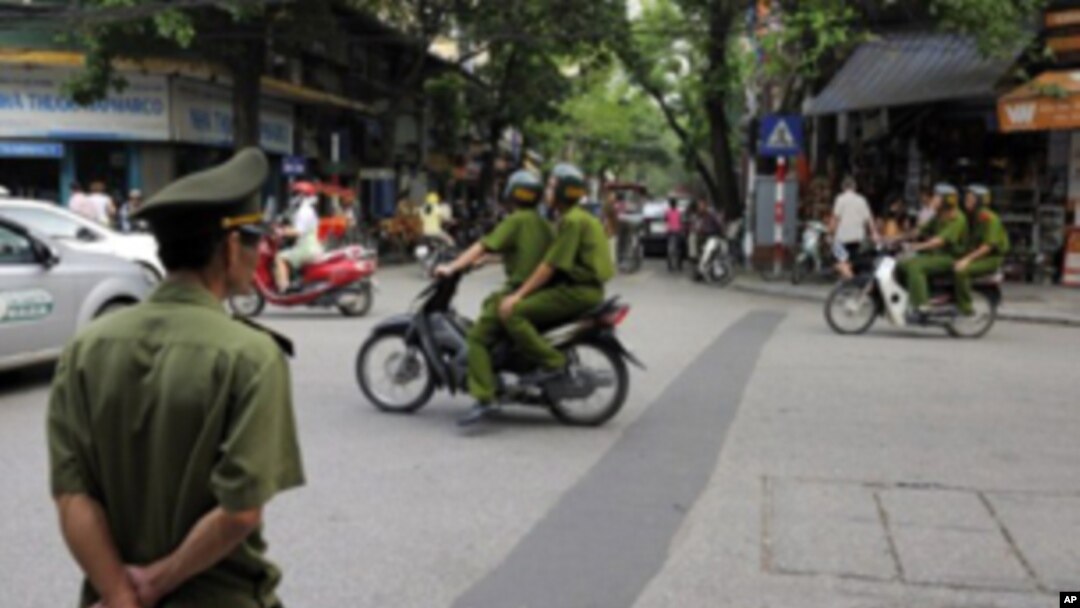 Policemen on motorcycle in Hanoi, Vietnam, June 11, 2010