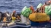 FILE - Seorang migran dibantu mengevakuasi perahu karet yang kempes sebagian oleh petugas penyelamat kapal kemanusiaan SOS Mediterranee Ocean Viking di Laut Mediterania Tengah, Rabu, 13 Maret 2024. (Johanna de Tessieres/ SOS Mediterranee via AP, HO)