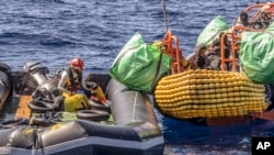 FILE - Seorang migran dibantu mengevakuasi perahu karet yang kempes sebagian oleh petugas penyelamat kapal kemanusiaan SOS Mediterranee Ocean Viking di Laut Mediterania Tengah, Rabu, 13 Maret 2024. (Johanna de Tessieres/ SOS Mediterranee via AP, HO)