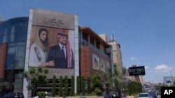 Images of Jordan's Crown Prince Hussein and his fiancee, Saudi architect Rajwa Alseif, adorn the front of a building in Amman, Jordan, May 30, 2023.