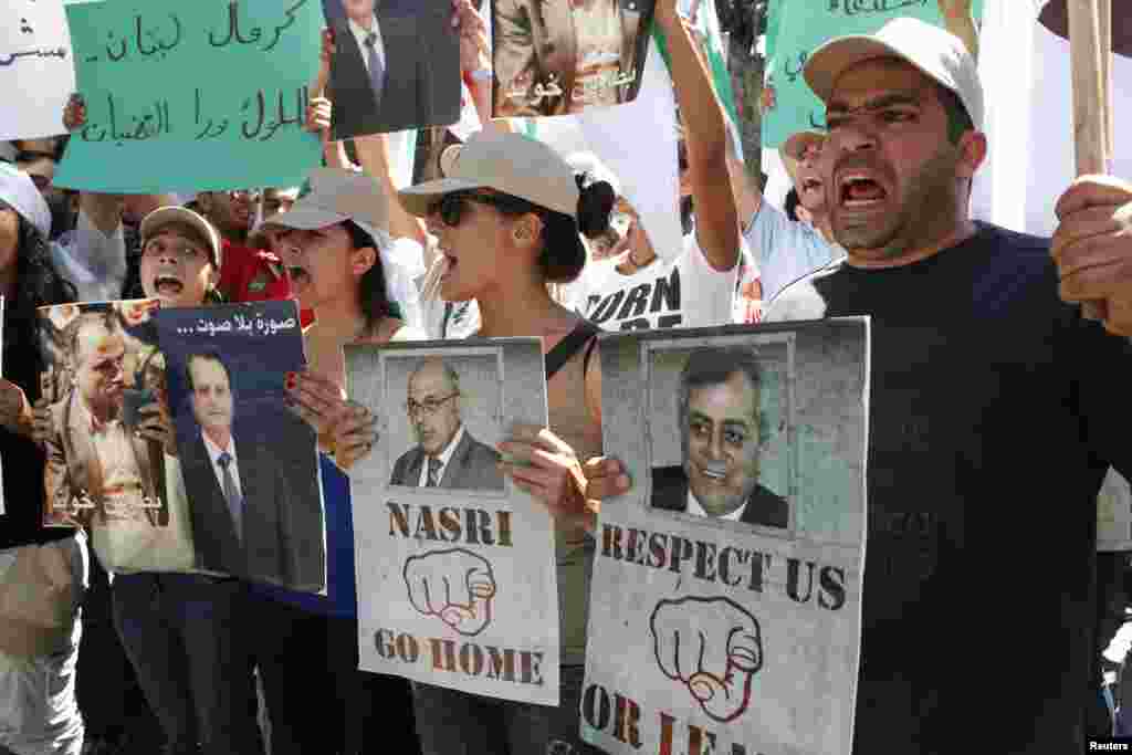 Student supporters of the Lebanese Christian Phalange party chant slogans and hold placards during a protest demanding the expulsion of the Syrian Ambassador Ali Abdul Karim Ali (R image) from Lebanon, in front of the Ministry of Foreign Affairs in Beirut