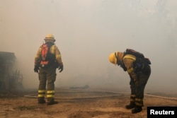 Los bomberos descansan mientras trabajan para extinguir un incendio forestal, en Quito, Ecuador, el 24 de septiembre de 2024. REUTERS/Karen Toro