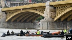 Para petugas penyelamat bersiap mengevakuasi kapal yang tenggelam di bawah Jembatan Margaret, Budapest, Hongaria, 30 Mei 2019.
