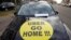 FILE - A striking French taxi drivers displays the message, "Uber Go Home" during a national protest about competition from private car ride firms like Uber, in Paris, Jan. 26, 2016. 