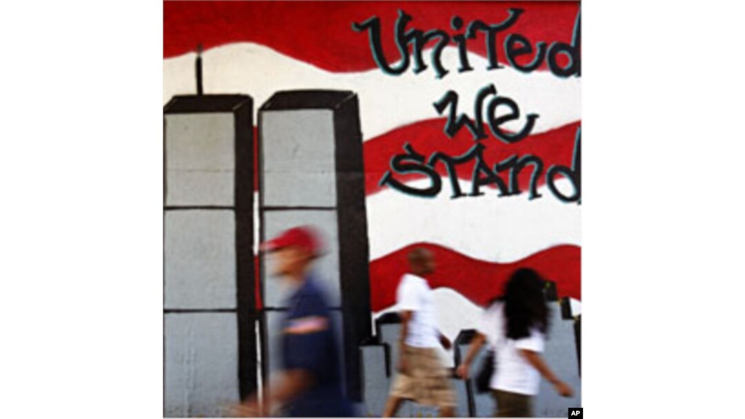 People walk past a mural honoring victims of the September 11 attacks on the World Trade Center, in the Queens borough of New York August 1, 2011