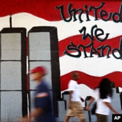 People walk past a mural honoring victims of the September 11 attacks on the World Trade Center, in the Queens borough of New York August 1, 2011