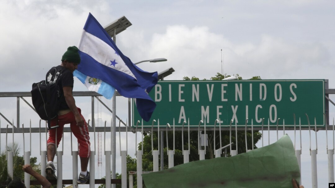 Caravana de migrantes derriba valla fronteriza para llegar a M xico