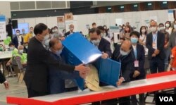 香港选管会主席冯骅(前排右二)与政制及内地事务局局长曾国卫(左二)9月19日晚在会展点票中心，监督选委会选举首个投票箱的开票过程 (美国之音/汤惠芸)