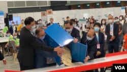 香港選管會主席馮驊（前排右二）與政制及內地事務局局長曾國衛（左二）9月19日晚在會展點票中心，監督選委會選舉首個投票箱的開票過程 (美國之音湯惠芸)