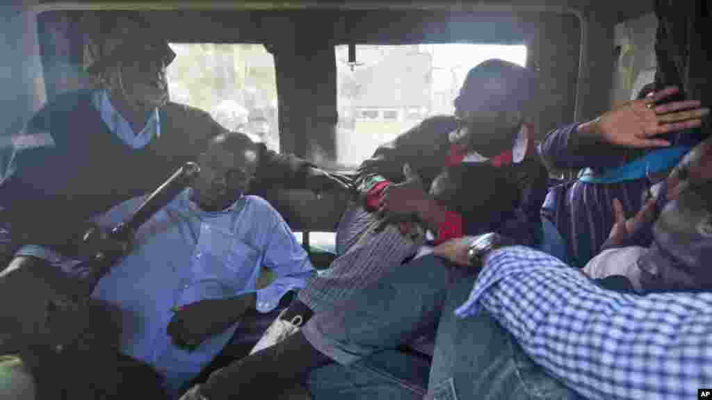 Des manifestants sont battus avec des gourdins au dos à bord d&#39;une camionnette de la police après avoir été arrêté à l&#39;extérieur du bâtiment du Parlement à Nairobi, au Kenya jeudi 18 décembre 2014.
