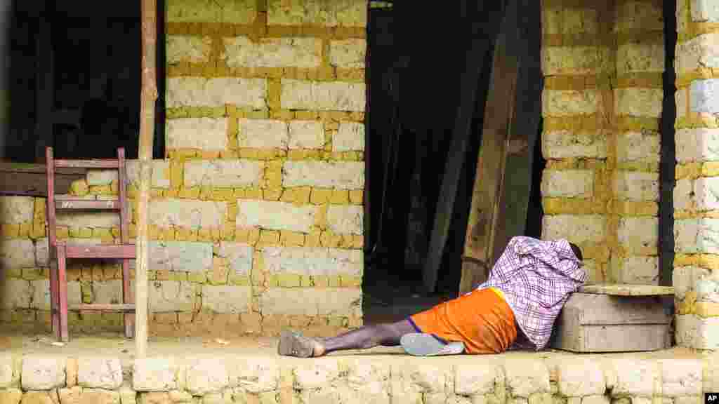 Un homme souffrant de virus Ebola couché sur le sol à l'extérieur d'une&nbsp;communautaire maison à Port Loko, situé à la périphérie de Freetown, Sierra Leone, le 21 octobre 2014.