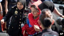 Istri mantan PM Malaysia Najib Razak, Rosmah Mansor (tengah) dikawal petugas ketika tiba di kantor komisi anti rasuah di Putrajaya, Malaysia, 5 Juni 2018 lalu (foto: dok).