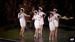 Members of North Korea's Moranbong band sing and dance during a joint performance with the State Merited Chorus in Pyongyang, North Korea. North Korea's Moranbong band, an all-female band formed by North Korean leader Kim Jong Un, has canceled its concerts in Beijing and abruptly left the Chinese capital for unknown reasons. 